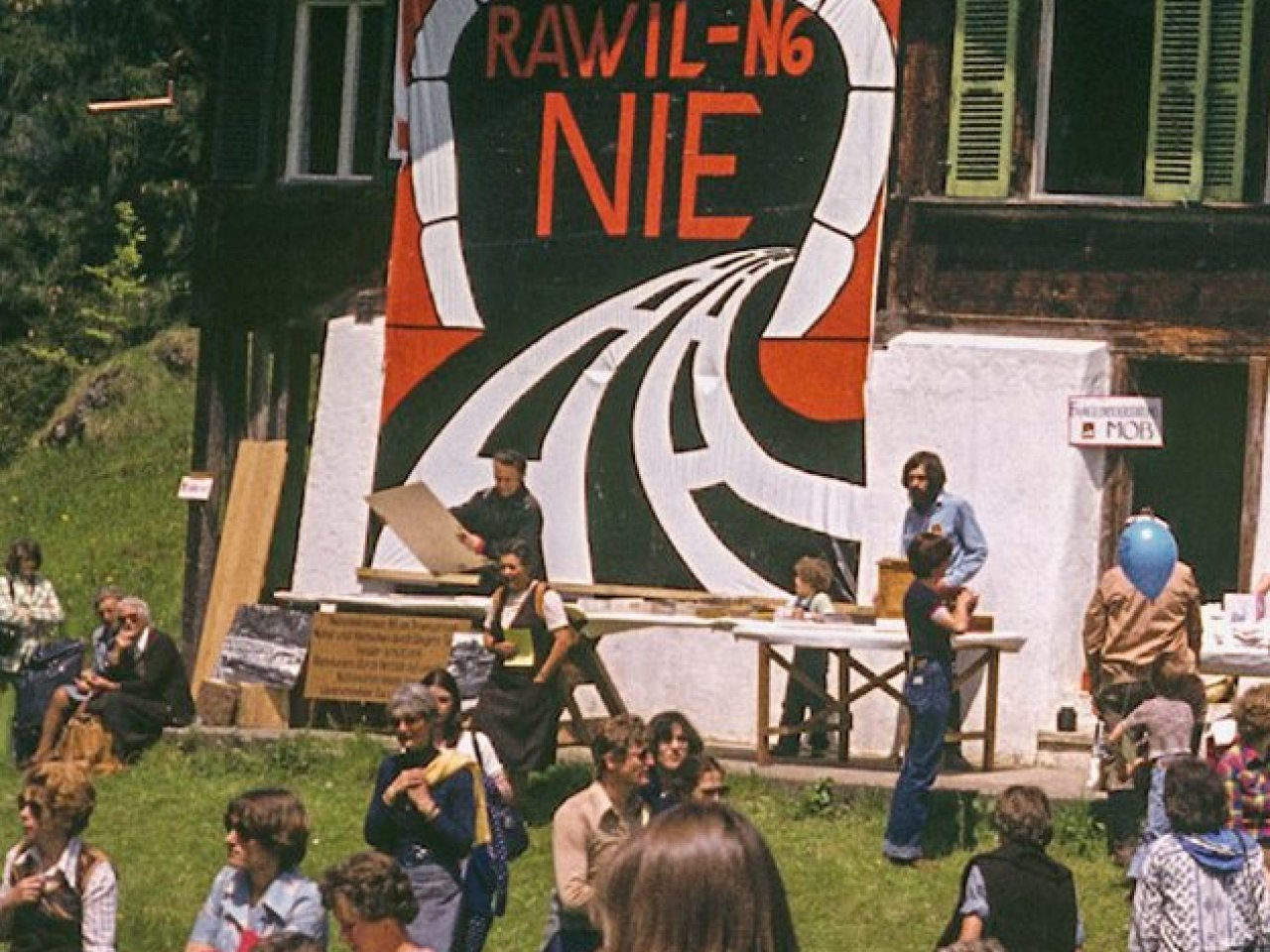 ein Fest..  im Vordergrund Leute, im Mittelpunkt das grosse Protest-Poster Rawil-N6... NIE